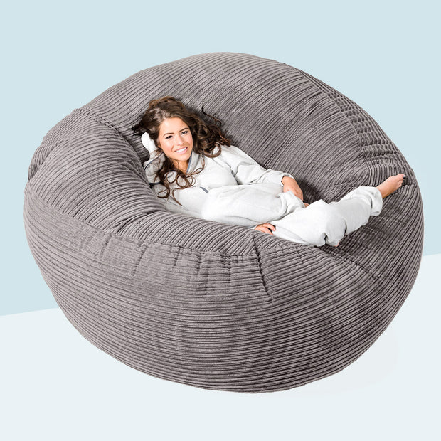 woman lounging on mega mammoth bean bag sofa in corduroy graphite grey