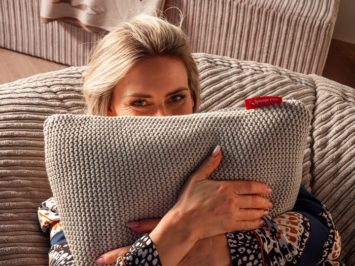 Woman on a cord bean bag holding a scatter cushion